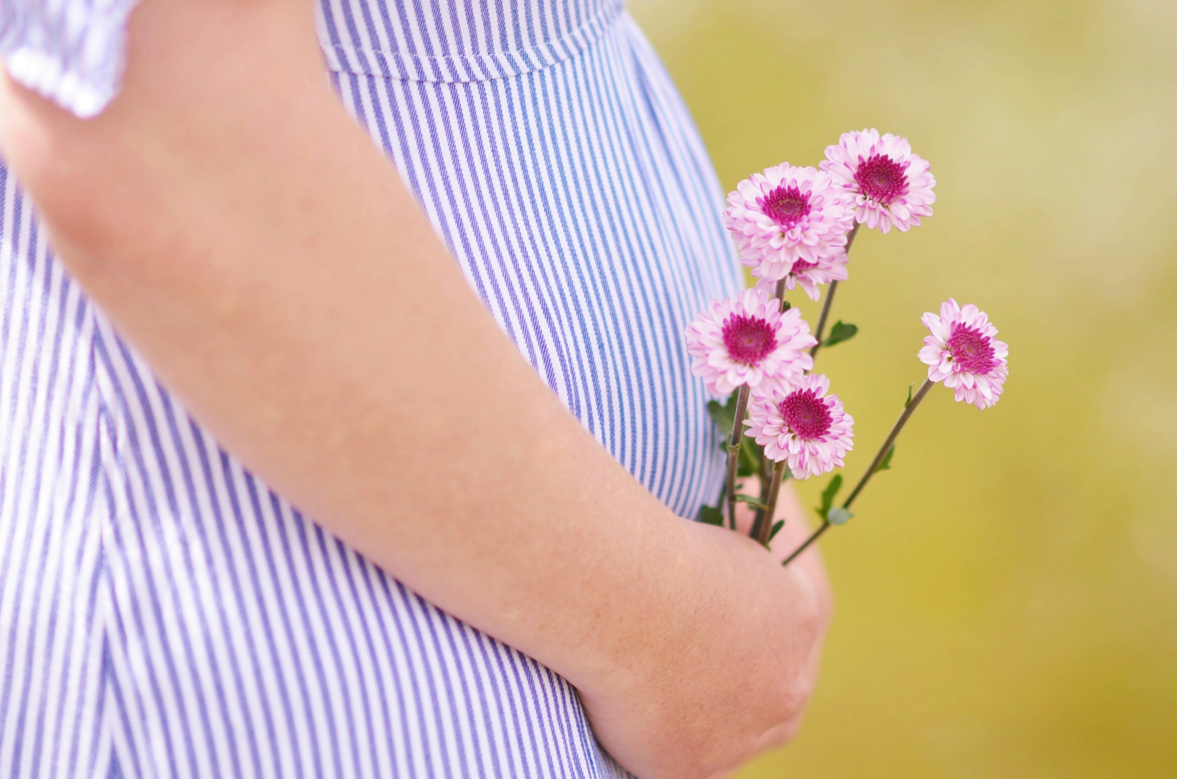 A mom holding flowers with her baby