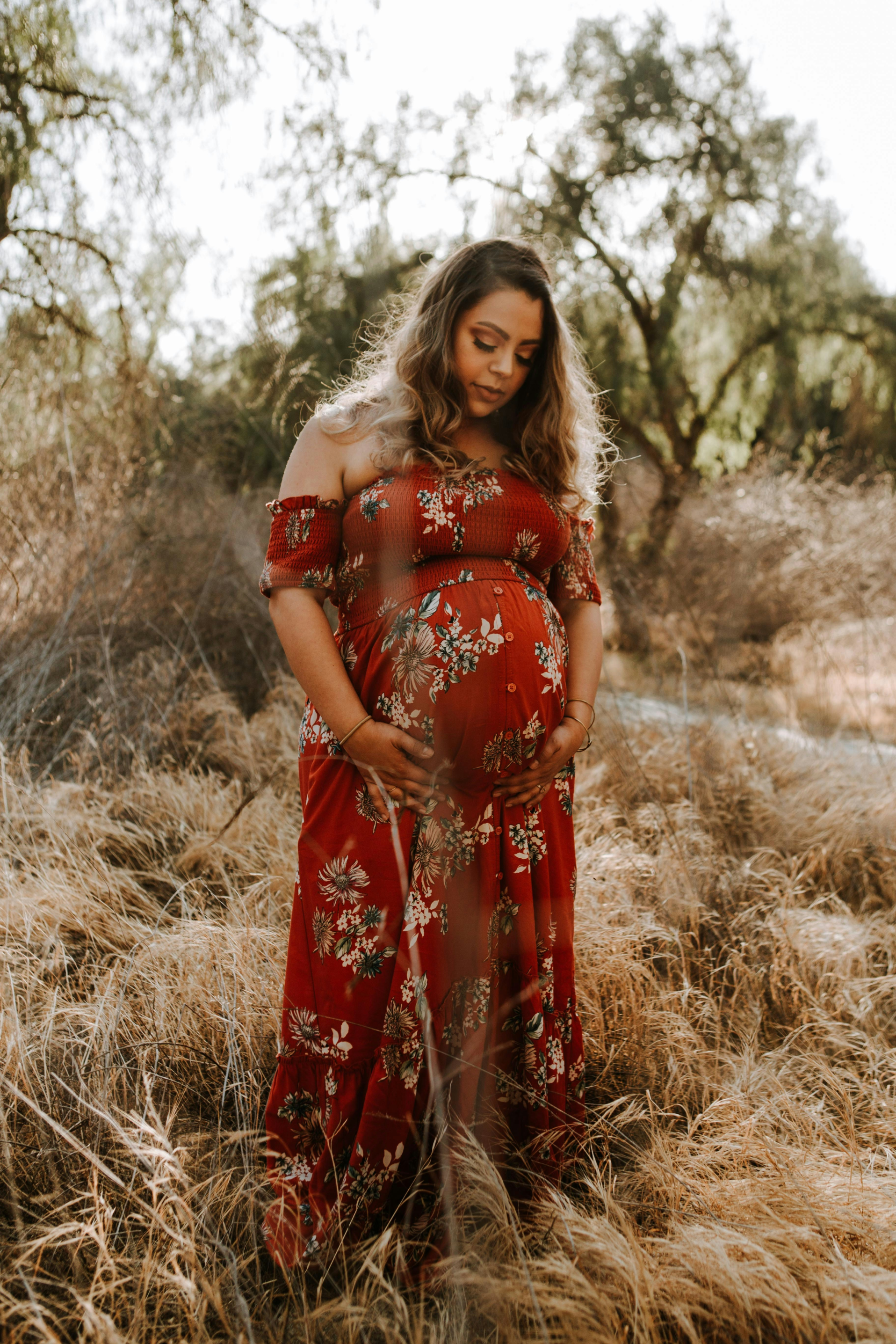 A mom in a red floral dress with her baby